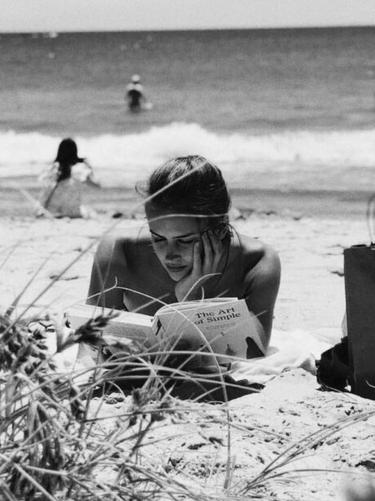Four Thousand Weeks book summary about time management, mortality, productivity, and meaningful living by Oliver Burkeman girl on beach reading